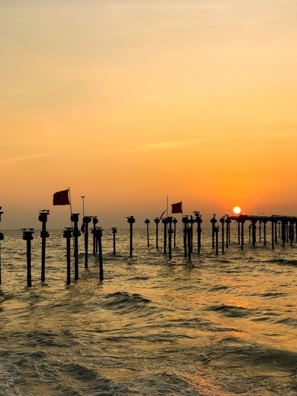Beautiful golden sunset view over the historic old sea bridge pier at Alappuzha Beach, Kerala
